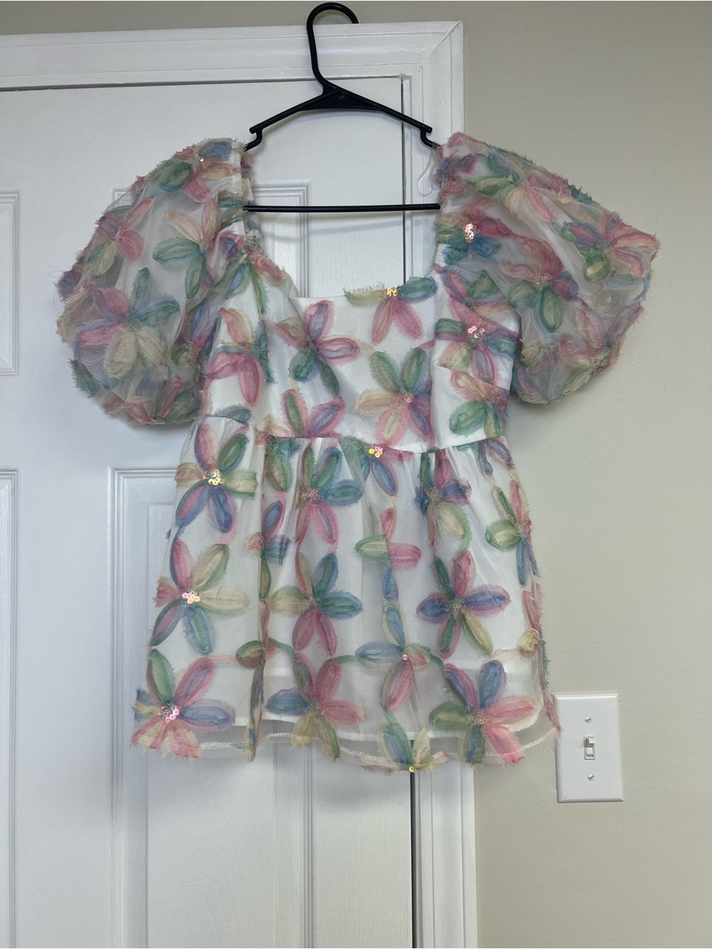 White short-sleeve top with a square neckline, puff sleeves, and 3D pattern